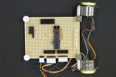 図2 今回は車輪の車輪(モーター)の位置を変え,LEDの反対側に光センサを配置しました。これがテープの位置を判別します。 図2 今回は車輪の車輪(モーター)の位置を変え,LEDの反対側に光センサを配置しました。これがテープの位置を判別します。