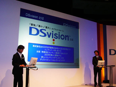 am3 専務取締役 澤居大介氏(右)は,実際にデモンストレーションなどを行いながらDSvisionの可能性について説明した。左は司会を務めたショーンK氏。同氏は「まるで持ち運びできるコンテンツのジュークボックスのようですね」とコメントした。 am3 専務取締役 澤居大介氏(右)とショーンK氏