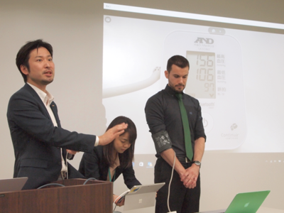 インフォテリア株式会社ネットサービス事業本部マーケティング部部長松村宗和氏(左)。発表会の最中,血圧測定をiPhoneと連携し,測定した数値をすべてデバイスに収集し,その後の分析やアドバイスにつなげる,といったシステム開発のデモを実施。ものの数分で完成した インフォテリア株式会社ネットサービス事業本部マーケティング部部長松村宗和氏(左)。発表会の最中,血圧測定をiPhoneと連携し,測定した数値をすべてデバイスに収集し,その後の分析やアドバイスにつなげる,といったシステム開発のデモを実施。ものの数分で完成した