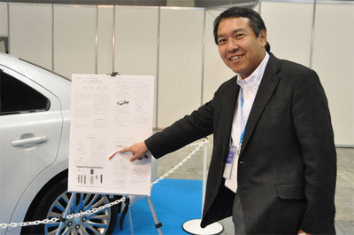 展示車の横に提示されていたスズキ自動車の技報にもTOPPERS OSの紹介が。指さしで説明しているのはTOPPERSプロジェクト会長の高田広章 名古屋大学教授。 展示車の横に提示されていたスズキ自動車の技報にもTOPPERS OSの紹介が。指さしで説明しているのはTOPPERSプロジェクト会長の高田広章 名古屋大学教授。